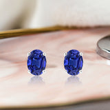2.5 Carat Oval Cut - Blue Sapphire - September Birthstone Solitaire Stud Earrings - 4 Prong - In 18K White Gold Plating Over Silver