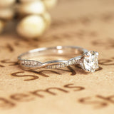 Cathedral Prong 1.25 Carat Round Shaped Moissanite Half Pave Infinity Twisted Shank Engagement Ring In 18K White Gold Plating Over Silver