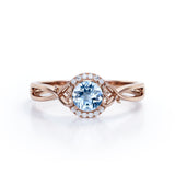 Modern Halo 1.50 Carat Round Cut Vivid Blue Aquamarine and Diamond Heart Twist Engagement Ring