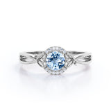 Modern Halo 1.50 Carat Round Cut Vivid Blue Aquamarine and Diamond Heart Twist Engagement Ring