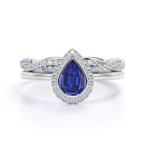 Dazzling Bezel Set 2.25 Carat Pear Cut Sapphire and Diamond Halo Bridal Set with Infinity Band in White Gold
