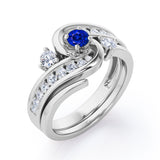 Twisted Tension - Prong 1 TCW Round Brilliant Cut Blue Sapphire and Moissanite - Flush Channel Wedding Set in White Gold