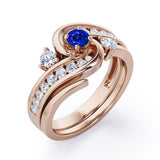 Twisted Tension - Prong 1 TCW Round Brilliant Cut Blue Sapphire and Moissanite - Flush Channel Wedding Set in White Gold